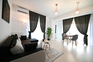 - un salon avec un canapé et une table dans l'établissement Novus Apartment, à Mamaia Nord – Năvodari