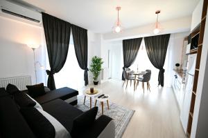 een woonkamer met een bank en een tafel bij Novus Apartment in Mamaia Nord – Năvodari