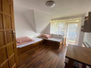 mały pokój z 2 łóżkami i oknem w obiekcie Dom Pod Lasem w Murzasichlu