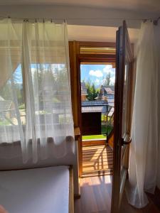 - une chambre avec une fenêtre donnant sur une maison dans l'établissement Dom Pod Lasem, à Murzasichle