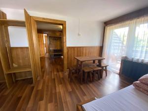 Pokój ze stołem i drewnianą podłogą w obiekcie Dom Pod Lasem w Murzasichlu