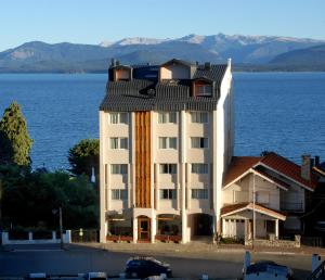 a large white building next to a large body of water at Hotel Tirol in San Carlos de Bariloche