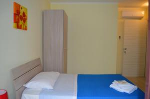 a bedroom with a bed with a blue and white blanket at Da zia Rosina in Lamezia Terme