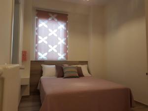 a small bedroom with a bed with a window at RosAmar in Bari