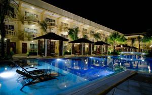 a swimming pool in front of a building at night at Henann Garden Resort in Boracay