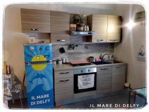 eine kleine Küche mit einem Kühlschrank und einem Herd in der Unterkunft Il Mare di Delfy in Lido di Ostia