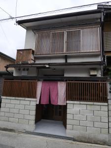 une maison avec des vêtements de séchage suspendus à un balcon dans l'établissement SAKURA Aburaya, à Takayama