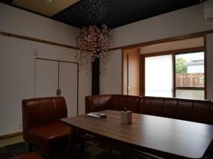 una sala da pranzo con tavolo e sedie in pelle di SAKURA Aburaya a Takayama