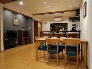 a dining room and kitchen with a table and chairs at Kanamori House in Takayama