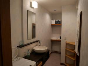 a bathroom with a sink and a large mirror at Kanamori House in Takayama