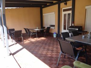une chambre avec des tables, des chaises et un piano dans l'établissement Villa La Vita, à Hévíz