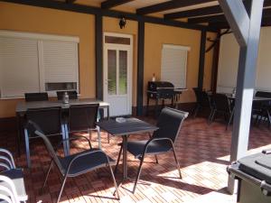 Villa La Vita في هفيز: غرفة بها كراسي وطاولات في غرفة بجدران صفراء