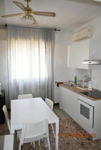 a kitchen with a white table and chairs and a sink at Appartamento Daniele in Mestre