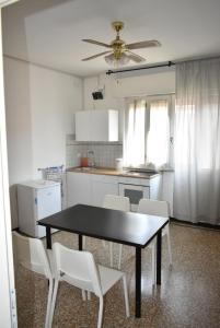 a kitchen with a black table and white chairs at Appartamento Paola in Mestre