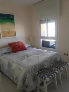 Schlafzimmer mit einem Bett mit einem roten Kissen und einem Fenster in der Unterkunft Apartamento Bruselas in Torrox Costa