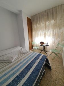 Schlafzimmer mit einem Bett, einem Tisch und einem Fenster in der Unterkunft Casa Mara in Zamora