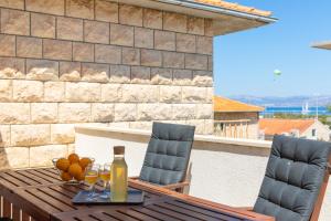 a wooden table with two chairs and a bottle of wine at Holiday home Kate Supetar in Supetar