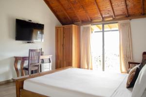 a bedroom with a bed and a desk and a window at Hotel Santa Isabel in Pereira