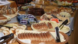 uma mesa com vários tipos diferentes de alimentos em HOTEL SÃO NICOLAU em Ubatuba