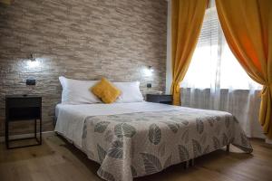 a bedroom with a bed and a brick wall at Aurelia Rooms in Verona