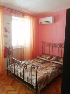 a bedroom with a bed with pink walls and a window at Apartment Filip in Vrbnik