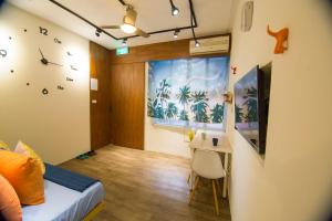 1 dormitorio con 1 cama y escritorio en una habitación en One Heart Inn, en Tainan