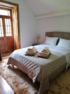 een slaapkamer met een bed met handdoeken erop bij Casa Real in Barcelos