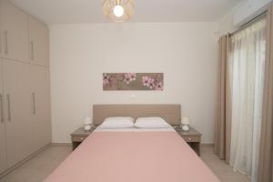 Οίνου Γη Ιθάκη - Winelandithaca في Perakhórion: غرفة نوم بسرير ودهان على الحائط
