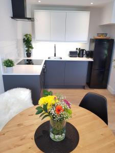 a vase of flowers sitting on a table in a kitchen at Woodcock Farm in Glossop