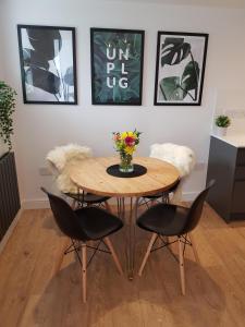a table with chairs and a vase of flowers on it at Woodcock Farm in Glossop