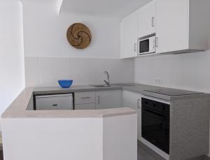 a kitchen with white cabinets and a counter top at Bayside Salgados in Albufeira