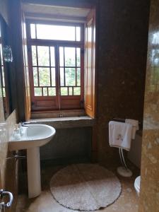 a bathroom with a sink and a window at Casa Real in Barcelos