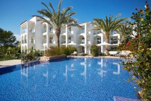a large swimming pool in front of a hotel at Insotel Tarida Beach Resort & SPA in Cala Tarida