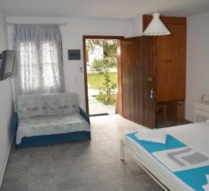 1 dormitorio con 1 cama, 1 silla y 1 puerta en Villa Molos, en Limenas