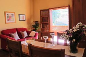 Una sala de estar con una mesa y un sofá rojo. en Casa Rural La Pitanga, en Hermigua 22 fotos más