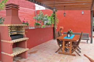a patio with a wooden table and a fireplace at Casa Rural La Pitanga in Hermigua
