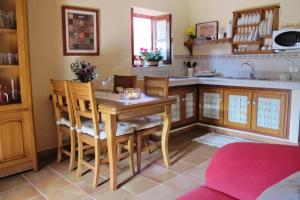 cocina con mesa de madera y sillas en Casa Rural La Pitanga, en Hermigua