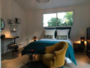 a bedroom with a bed and a chair and a window at Villa NOVA in Saint-Hilaire-de-Riez +29 photos