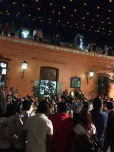 una multitud de personas de pie en frente de un edificio en Parador Monte Carmelo en Oaxaca de Juárez