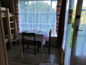 a table and chairs in a room with a window at Pod Gwiazdami Lejkowo in Lejkowo