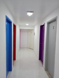 a hallway with four doors in different colors at Guest House Renascer K&W in Cabo Frio +113 photos