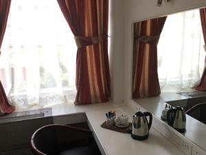 a kitchen with two windows and a counter with a tea kettle at Savoy Hotel Kimberley in Kimberley