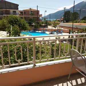 a balcony with a chair and a swimming pool at Kalias Hotel in Vasiliki