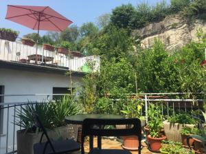 a patio with a table and an umbrella and plants at San Nazaro 55 in Verona