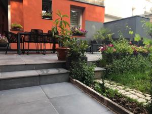 a patio with a table and chairs and flowers at VIP 67 in Eupen