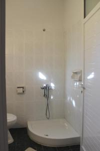 a bathroom with a shower with a tub and a toilet at Germanos Studios in Kato Loutraki