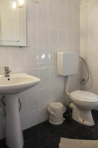 a white bathroom with a sink and a toilet at Germanos Studios in Kato Loutraki +16 photos