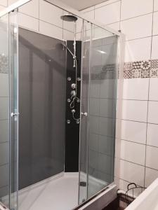 una ducha con puerta de cristal en un baño en GrIsa'Home le gîte, en Aisonville-et-Bernoville