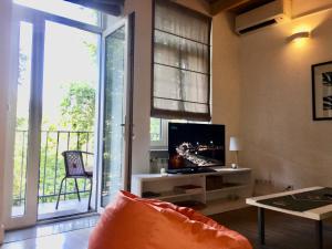 un soggiorno con TV e ampia finestra di The White Loft a Tbilisi City