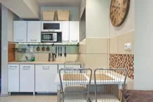 a kitchen with a table and two chairs and a clock at Aba Apartamenty Piłsudskiego 41 in Krynica Zdrój